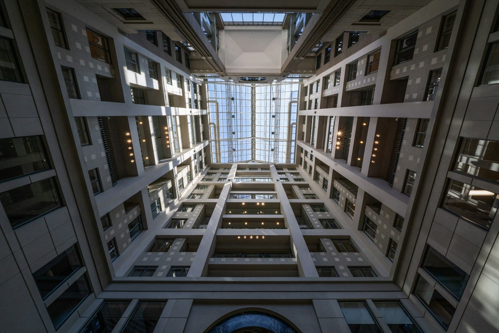Institutional building atrium rising toward a glass skylight